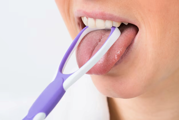 mujer limpiando su boca de bacterias con un raspador de lengua para evitar enfermedades bucodentales que pueden hacerle enfermar de corazón